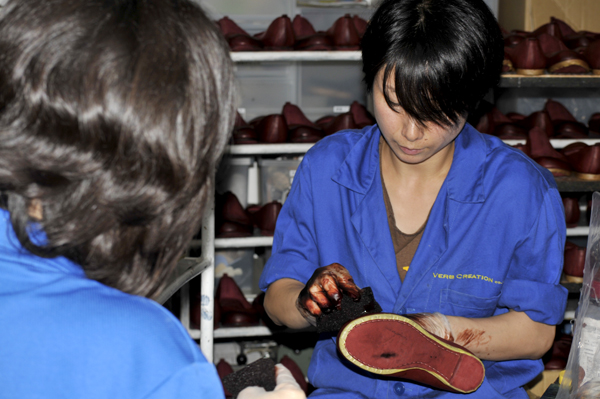 写真：職人の皆さんは全員「Verb Creation」の刺繍の入った制服とおそろいの靴を着用で作業。こちらの職人さんは靴に染色中