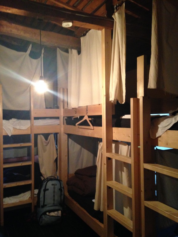 オリジナルで造作した2段ベッドが並べられたドミトリー。それぞれカーテンで仕切られていて、1人の空間がゆるく保たれている。各ベッドにコンセントと読書灯付き。 